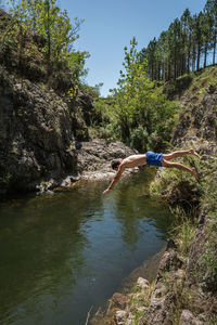 Man standing on rock against trees