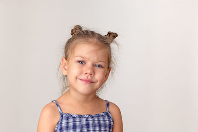 Portrait of smiling young woman standing against wall