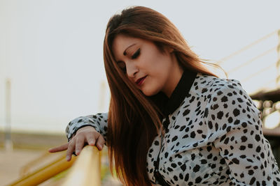 Young woman looking away while sitting outdoors