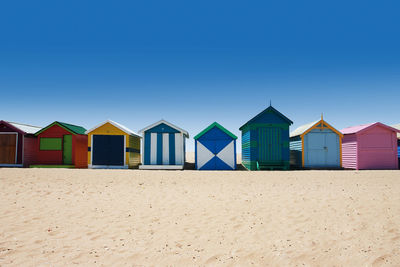 Beach huts against clear blue sky