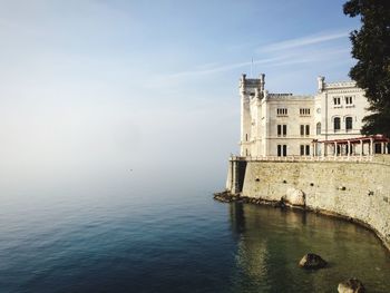 Miramare castle by sea against sky