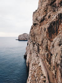 Rock formations by sea against sky