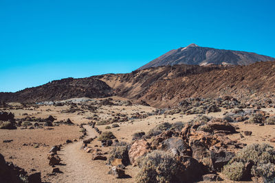 Scenic view of desert against clear blue sky