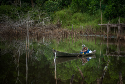 Man sitting in boat on lake