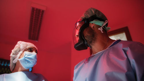 Medical staff in emergency surgical room with red alarm