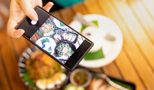 High angle view of person using mobile phone on table