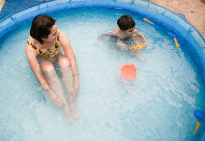 High angle view of mother and son swimming in pool