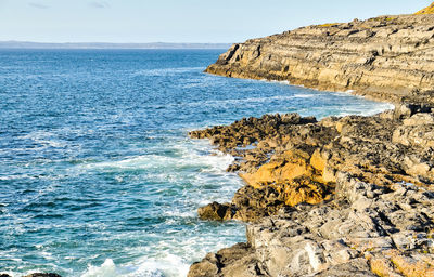 Scenic view of rock formation in sea against sky