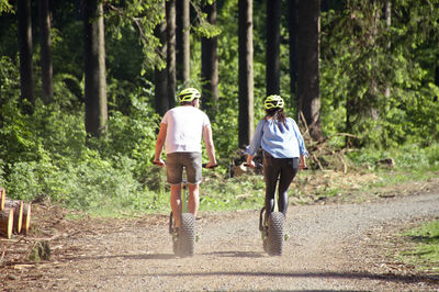 Rear view of people riding bicycles on road