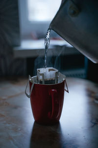 A jet of water pours into the coffee filter, homemade drink, ground caffeine into the filter bags