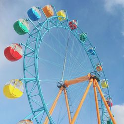 Low angle view of ferris wheel against blue sky