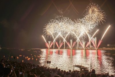 Firework display over lake at night