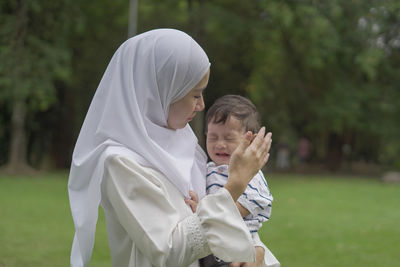 Mother with son standing outdoors