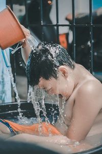 Midsection of man splashing in water