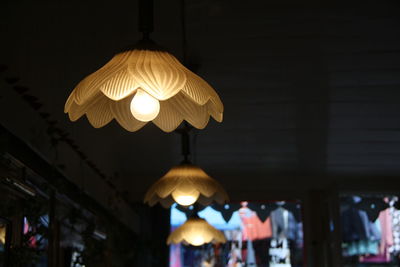 Low angle view of illuminated pendant light hanging in store