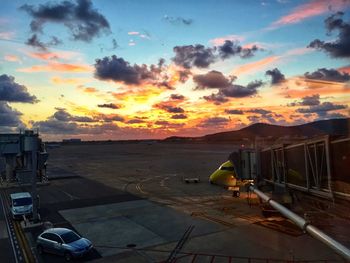 Airport runway against sky during sunset