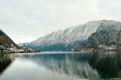 Scenic view of lake by snowcapped mountains against sky