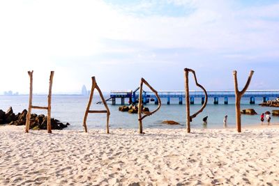 Wooden posts on beach against sky