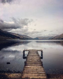 Pier over lake against sky