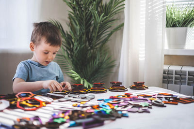 Portrait of cute boy playing with toys at home