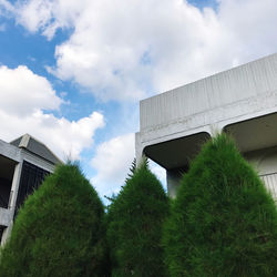 Low angle view of bridge amidst plants and building against sky