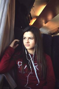 Portrait of beautiful young woman sitting in bus