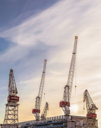 Cranes at construction site against sky