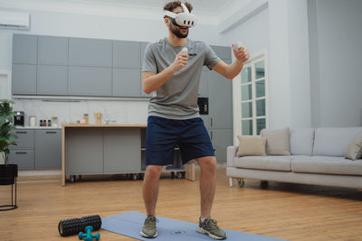 Full length of young woman exercising at home