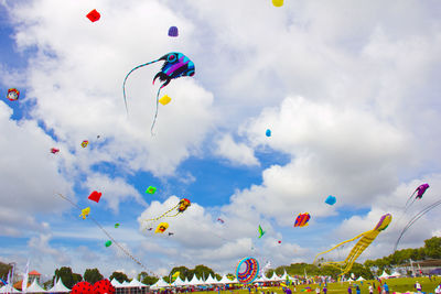 Low angle view of colorful kites flying against sky