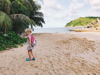 Girl playing on beach against sky