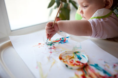 Cute girl painting while sitting at home