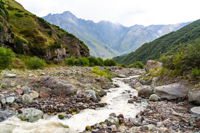 River flowing amidst mountains against sky