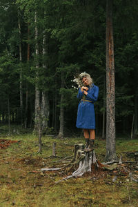 Girl in a blue dress on the background of the forest