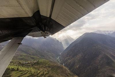 Mountain village & valley viewed past small plane wing, nepal himalaya