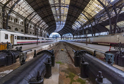 Trains on the platforms of a barcelona station with a fantastic roof