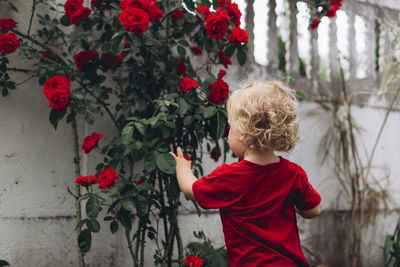 Rear view of boy standing against wall