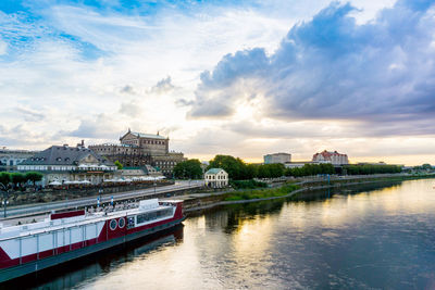 View of river in town against cloudy sky