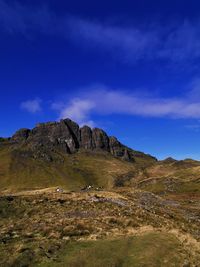 Scenic view of landscape and mountains against blue sky