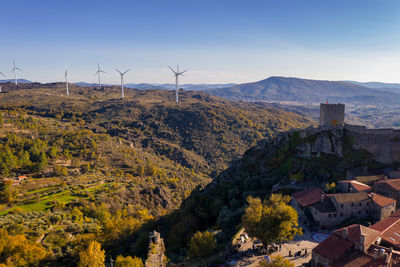 Drone aerial panorama of historic village of sortelha with castle and with turbines