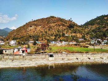 Houses by lake against sky