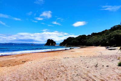 Scenic view of beach against blue sky