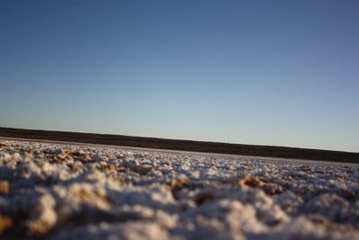 Surface level of railroad track against clear blue sky