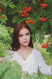 Portrait of beautiful woman with red flower