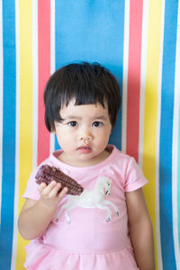 Portrait of girl standing against wall