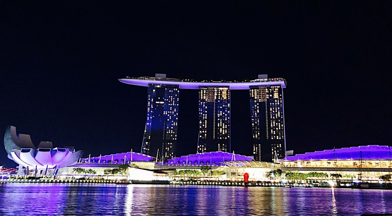 ILLUMINATED MODERN BUILDING AT WATERFRONT