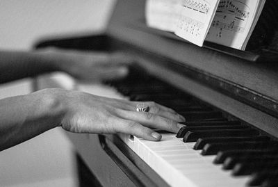 Close-up of hand playing piano