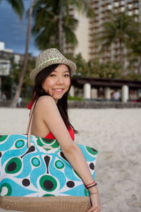 Side view portrait of smiling woman standing at beach