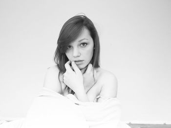 Portrait of young woman against white background