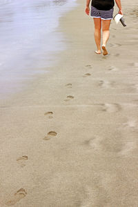 Low section of woman walking on beach