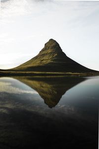 Scenic view of lake by mountain against sky